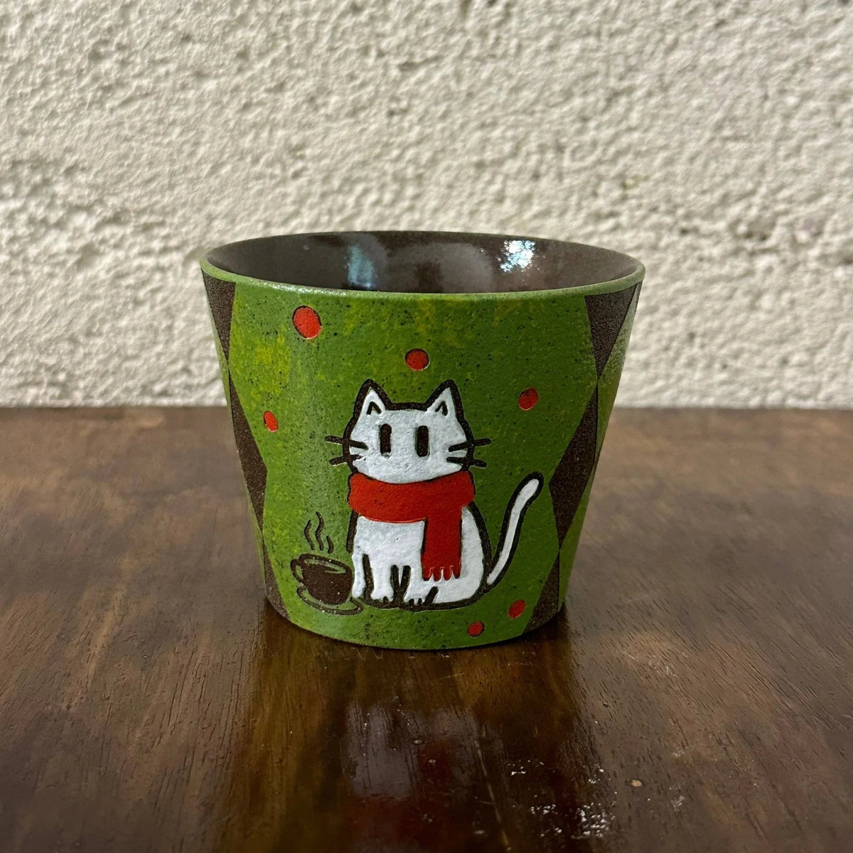 Handmade ceramic mug with cute white cat in red scarf, green speckled glaze, and coffee cup design