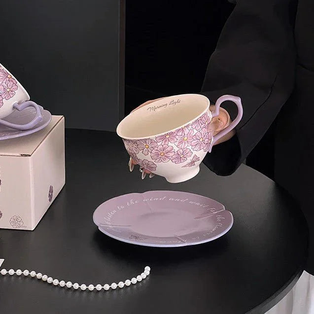 Hand-painted floral ceramic tea cup and saucer set with delicate purple flowers, perfect for morning tea or coffee moments.