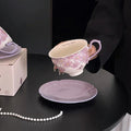 Hand-painted floral ceramic tea cup and saucer set with delicate purple flowers, perfect for morning tea or coffee moments.